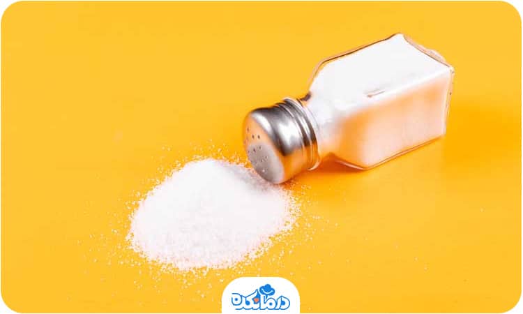 یک نمکدان که روی زمین افتاده و مقداری نمک از آن بیرون ریخته است
