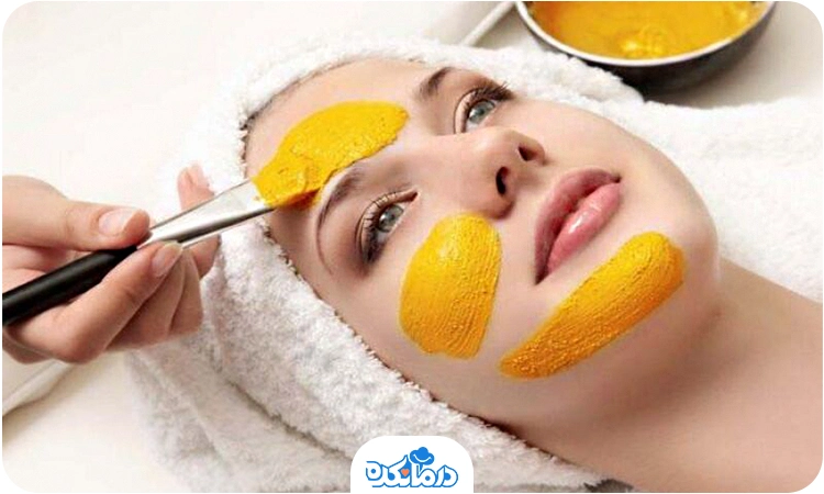 یک زن جوان که روی صورت خود ماسک زرده تخم‌مرغ و عسل گذاشته است